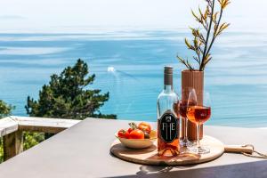 una mesa con dos copas de vino y un tazón de fruta en The View - Coast & Country en Onetangi