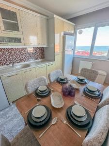 einen Esstisch mit Tellern und Küchenutensilien in der Unterkunft Grand Crown Suites - شقق غراند كراون السياحية in Trabzon