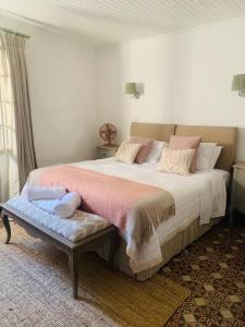 ein Schlafzimmer mit einem großen Bett mit rosa Kissen in der Unterkunft Beautiful South of France Home with Pool in Gabian