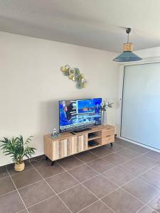 sala de estar con TV de pantalla plana sobre una mesa en Wave Coconut Villa en Le Moule