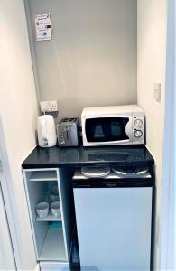 a microwave sitting on a counter in a kitchen at Deluxe Double Room with Private Amenities in Banbury