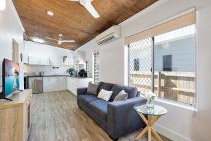 sala de estar con sofá y cocina en Seaside Serenity Modern Cottage with Spa, en Machans Beach