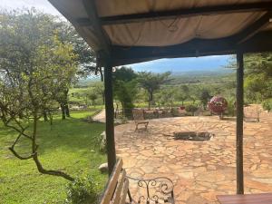 a patio with a bench and a fire pit at Sunset camp in Narok
