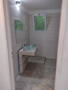 La salle de bains est pourvue d'un lavabo et d'un miroir. dans l'établissement El parquecito, à Tandil