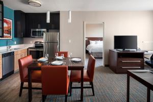 a kitchen and dining room with a table and chairs at Residence Inn by Marriott Boston Watertown in Watertown