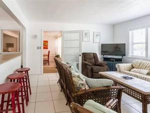 a living room with a bunch of chairs and a table at Lovely 1 Bedroom Unit Across from Lido Key Beach in Sarasota