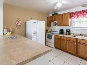 a kitchen with a white refrigerator and wooden cabinets at Lovely 1 Bedroom Unit Across from Lido Key Beach in Sarasota
