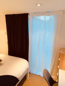 a bedroom with a bed and a blue curtain at Deluxe Double Room with Private Amenities in Banbury