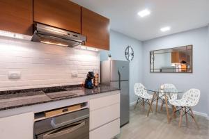 eine Küche mit einem Kühlschrank und einem Tisch mit Stühlen in der Unterkunft Mv depa - Unico y exclusivo departamento en el centro de Córdoba in Cordoba