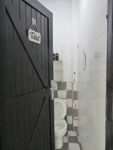 a bathroom with a black door and a toilet at Rumah Kembar DI kawasan wisata lembang in Citeureup 1