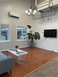 a living room with a table and a tv at The Grand Beach Inn in Old Orchard Beach