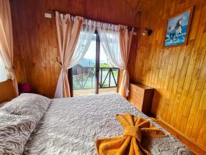 Un dormitorio con una cama y una ventana grande. en Cabañas Kompatzki, en Ancud 37 fotos más