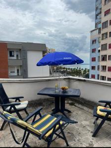 una mesa y sillas con una sombrilla azul en el techo en Ferienwohnung Durres Albania en Durrës
