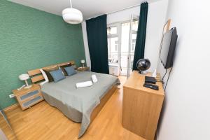 a bedroom with a bed and a flat screen tv at Paulay Opera Apartment in Budapest