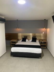sypialnia z dużym łóżkiem z czarno-białą pościelą w obiekcie HOTEL ESTADIO DORADO w mieście Medellín