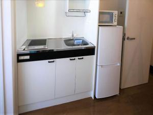 una piccola cucina con lavandino e frigorifero di Numero Uno Tokyo a Tokyo