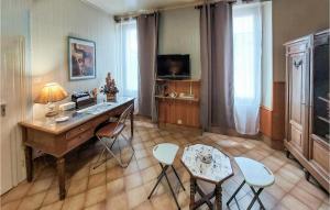 a room with a desk and chairs and a television at Lovely Home In Boussac With Kitchen in Boussac