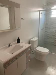 a bathroom with a toilet and a sink and a shower at Apto térreo novo 3 dorm - próximo ao centro in Poços de Caldas