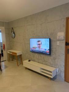 a living room with a flat screen tv on a wall at Apto térreo novo 3 dorm - próximo ao centro in Poços de Caldas