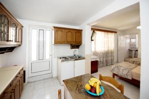 a kitchen with a table with a bowl of fruit on it at Maria Studios & Apartments in Kremasti