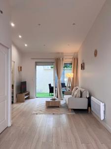 ein Wohnzimmer mit einem weißen Sofa und einem großen Fenster in der Unterkunft Superbe maison de ville proche Paris in Sannois