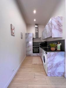 eine Küche mit Marmorarbeitsflächen, einer Waschmaschine und einem Trockner in der Unterkunft Superbe maison de ville proche Paris in Sannois