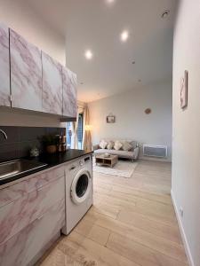 eine Küche mit Waschmaschine und Trockner im Zimmer in der Unterkunft Superbe maison de ville proche Paris in Sannois