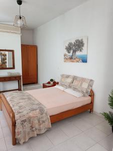 a bedroom with a bed and a painting on the wall at Maria Studios & Apartments in Kremasti