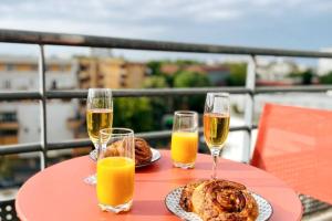 a table with two plates of food and two glasses of orange juice at Penthouse de standing: Vue paris- 10min de l'aéroport Orly - Parking gratuit in Orly