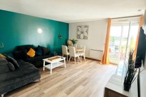 a living room with a couch and a table at Penthouse de standing: Vue paris- 10min de l'aéroport Orly - Parking gratuit in Orly