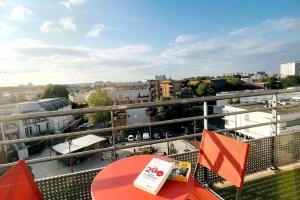 een balkon met een tafel en uitzicht op de stad bij Penthouse de standing: Vue paris- 10min de l'aéroport Orly - Parking gratuit in Orly