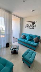 a living room with a blue couch and a table at Apartamento en Condomio Peñazul La Aldea en Ricaurte - Girardot in Ricaurte