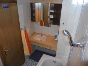 ein Bad mit einem Waschbecken und einem Spiegel in der Unterkunft Ferienhaus Nussbaumer in Sibratsgfäll