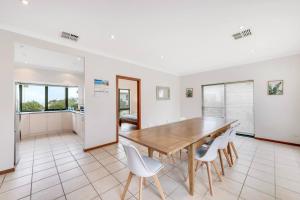 a dining room with a wooden table and white chairs at 10 Rupara - Linen Included in Hayborough