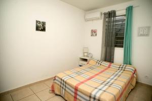 1 dormitorio con cama y ventana en Maison de l'ébène Pas, en Cayenne
