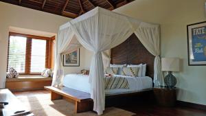 a bedroom with a white bed with a canopy at The New Villa Suar in Seminyak