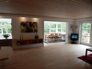 a living room with a table and chairs and windows at Kummelefort in Kruså