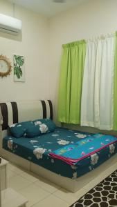 Bett in einem Zimmer mit Fenster in der Unterkunft illa Bella Homestay Jasin in Jasin