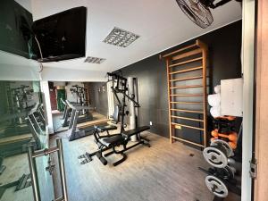 un gimnasio con máquinas de correr y un televisor en una habitación en Oasis Tower Hotel en Ribeirão Preto