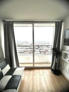 un soggiorno con una grande finestra e un divano di Departamento Cómodo y Luminoso a Santiago