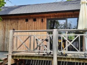 een houten hut met een poort en een veranda bij Cosy chalet near Durbuy in nature in Somme-Leuze