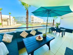 a patio with a blue couch and a table with an umbrella at Lucky Star Marina Apartment, with Pool in Lagos +44 photos