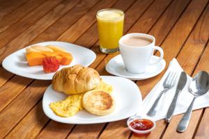 dois pratos de alimentos para o pequeno-almoço e uma chávena de café em Hotel Manantial Melgar Torre 2 em Melgar