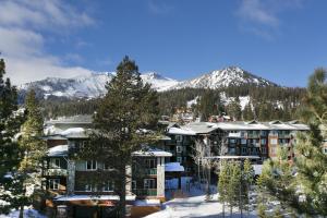 a resort with snow covered mountains in the background at Summit by 101 Great Escapes in Mammoth Lakes