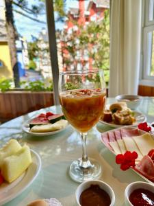 uma mesa coberta com pratos de comida e um copo de vinho em Natur Hotel em Gramado