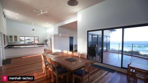 a kitchen and dining room with a table and a view of the ocean at Bermagui bliss beachfront holiday house in Bermagui