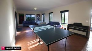 a ping pong table in a living room with a piano at Bermagui bliss beachfront holiday house in Bermagui