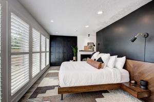 a bedroom with a large bed and a black wall at Off-Broadway - Modern woutdoor haven in Boise