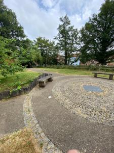 a park with two benches and trees in the background at Apt 5a Central by river 1 Bed Apartment in Norwich +3 photos