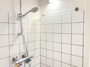 a shower in a bathroom with white tiles at 1 Bedroom Apartment In Kolding City Center in Kolding